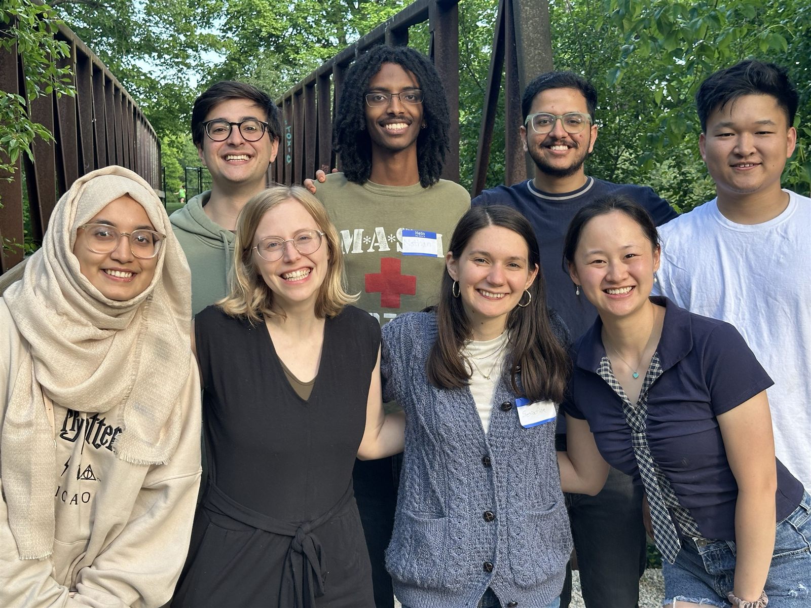 Eight REALIZE Lab members smiling together on a footbridge